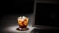 Glass of cola with ice and laptop on grey stone table on black background banner Royalty Free Stock Photo