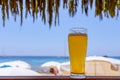 A glass of cold beer at a beach bar near the emerald sea Royalty Free Stock Photo