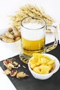 Glass of cold beer with chips and peanuts isolated on white back Royalty Free Stock Photo