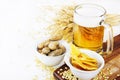 Glass of cold beer with chips and peanuts on white background Royalty Free Stock Photo