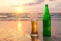 Glass of cold beer on the sea shore at the sunset. Relax on the beach. Royalty Free Stock Photo