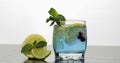 Glass with cold blue drink with leaves of mint, lime, lemon, black currants Royalty Free Stock Photo