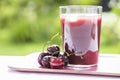 Glass of Cold cherry juice in garden