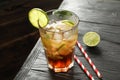 Glass of cold cola with citrus and ice on wooden table Royalty Free Stock Photo