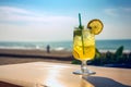 Glass of cold fresh summer cocktail on wooden table with ocean view on background Royalty Free Stock Photo