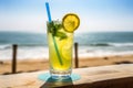 Glass of cold fresh summer cocktail on wooden table with ocean view on background Royalty Free Stock Photo