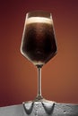 Glass of cold frothy dark beer on an old wooden table Royalty Free Stock Photo