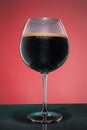 Glass of cold frothy dark beer on an old wooden table Royalty Free Stock Photo