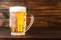 Glass of cold frothy lager beer on old wooden table Royalty Free Stock Photo