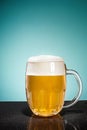 Glass of cold frothy lager beer on an old wooden table Royalty Free Stock Photo