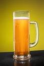 Glass of cold frothy lager beer on an old wooden table Royalty Free Stock Photo