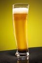 Glass of cold frothy lager beer on an old wooden table Royalty Free Stock Photo