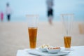 Glass of cold iced tea with sliced lemons on the beach with seascape background Royalty Free Stock Photo