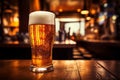 Glass of cold lager beer on bar counter with condensation and wooden bar background Royalty Free Stock Photo