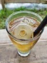 a glass of cold lemon tea with some ice cubes on a natural landscape background Royalty Free Stock Photo