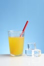 Glass of cold orange juice with straw