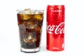 Glass of cold refreshing coca cola soda with ice, metal can of coca cola classic, isolated on white Royalty Free Stock Photo