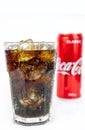 Glass of cold refreshing coca cola soda with ice, metal can of coca cola classic, isolated on white Royalty Free Stock Photo
