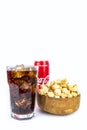 Glass of cold refreshing coca cola soda with ice, metal can of coca cola classic, wooden bowl of fresh caramel popcorn, isolated Royalty Free Stock Photo