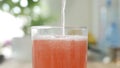 A Glass with Cold, Sweet, Acidulated, and Refreshing Grapefruit Drink. Shooting with a Glass Filled with a Fresh and Tasty Drink.