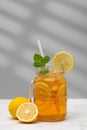 A glass of cold tea, ice cubes, lemon slices and a sprig of mint. Cooling summer drinks. Royalty Free Stock Photo