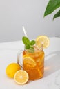 A glass of cold tea, ice cubes, lemon slices and a sprig of mint. Cooling summer drinks. Royalty Free Stock Photo