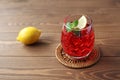 glass of cold tea red drink with lemon isolated on wooden table Royalty Free Stock Photo