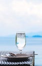 Glass of cold water on dining table with blue ocean background Royalty Free Stock Photo