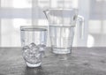 Glass of cold water with ice cubes on grey table Royalty Free Stock Photo