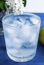 A glass of cold water with ice and lemon on a blue background Royalty Free Stock Photo