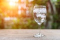 Glass of cold water with ice on table with blur nature garden ba Royalty Free Stock Photo