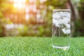 Glass of cold water with ice on table with blur nature garden ba Royalty Free Stock Photo