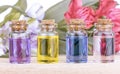 Glass colorful bottles aroma oil and flowers on wooden table