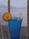 A glass of colorful fresh drink with a beach bakcground Royalty Free Stock Photo