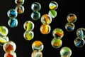 Glass , colorful marbles with reflexion. Childhood games concept. Reflexion on mirror. Black concept background