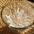 Top down flass container of cotton swabs with wicker background