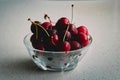 Glass container of fresh cherries on a marble table ready to serve. White background and perfect for adding text Royalty Free Stock Photo