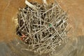 Glass container with a heap of silver pins used in clothing garment industry