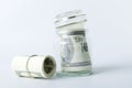 Glass container for money savings, rolled cash on the white background Royalty Free Stock Photo