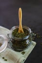 Glass container with mung beans. Transparent pot open on a tablecloth full of vegetables with a wooden spoon Royalty Free Stock Photo