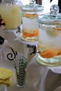 Glass containers of fruit infused water on buffet table