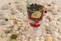 Glass with a cooling drink of berries and ice. Misted glass. Air bubbles on glass. A slice of lemon on a plate on the background Royalty Free Stock Photo