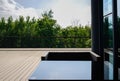 Glass-covered table and armchair on planked terrace in sunny sum Royalty Free Stock Photo