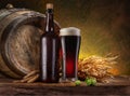 Glass of craft black beer, beer bottle and wooden cask on the wooden table in the cellar