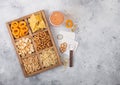 Glass of craft lager beer and opener with box of snacks on light background. Pretzel,salty potato sticks, peanuts, onion rings Royalty Free Stock Photo