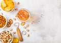 Glass of craft lager beer with snack and opener on stone kitchen table background. Pretzel and crisps and pistachio in white ceram Royalty Free Stock Photo