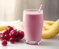 A glass of cranberry and banana smoothie, with cranberries and banana