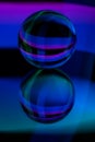 Glass crystal ball on a mirror surface with a blue and purple pattern light painting fractals Royalty Free Stock Photo