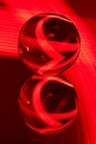 Glass crystal ball on a mirror surface with a red pattern light painting Royalty Free Stock Photo