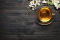 Glass cup of aromatic jasmine tea, dry leaves and fresh flowers on black wooden table, flat lay. Space for text Royalty Free Stock Photo